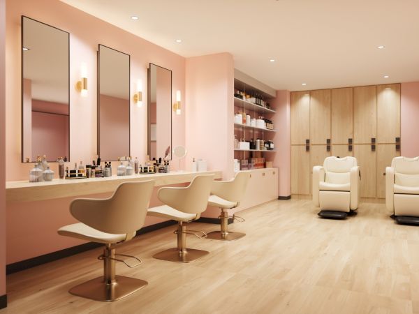A modern hair salon with three styling chairs, large mirrors, a stocked counter, pendant lights, and a wood-paneled storage wall.